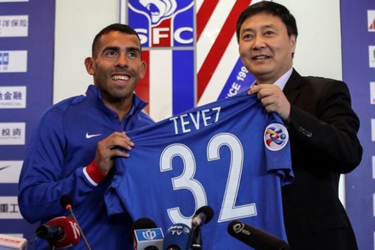 Striker asal Argentina, Carlos Tevez (kiri), berpose dengan jersey klub barunya, Shanghai Shenhua, dalam jumpa pers di Shanghai pada 21 Januari 2017. Tevez melakukan jumpa pers pertamanya bersama Shanghai Shenhua dan dia dilaporkan menjadi pemain dengan gaji tertinggi di dunia.