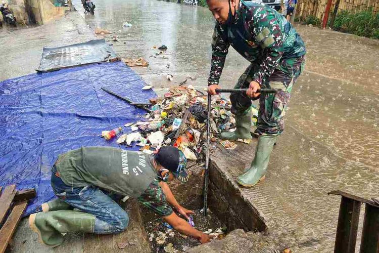 Personel TNI dari Sektor 21 Subsektor 15 Sumedang masuk gorong-gorong untuk membersihkan sampah yang menyumbat saluran anak Sungai Cimande di Cimanggung, Sumedang, Jawa Barat, Kamis (22/10/2020) sekitar pukul 14.18 WIB. Dok. Pendim Sumedang/KOMPAS.com