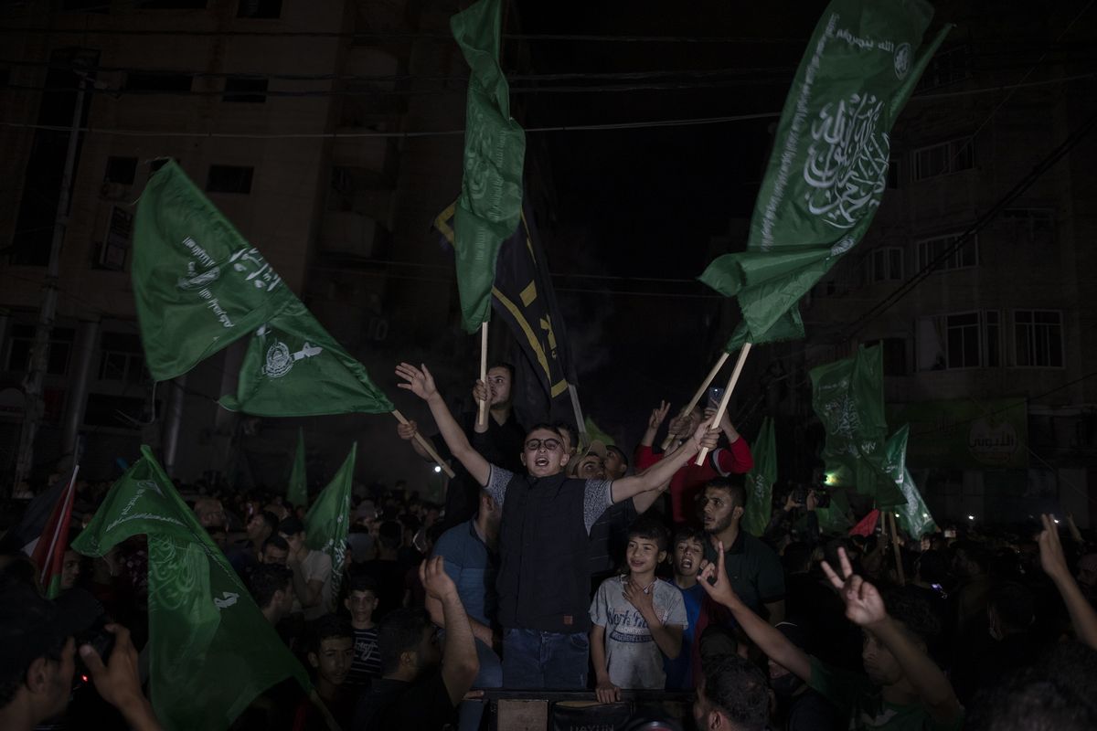 Warga Palestina pada Jumat (21/5/2021) mengibarkan bendera hijau Hamas sambil meneriakkan yel-yel merayakan gencatan senjata antara Israel dengan Hamas, setelah 11 hari konflik di Gaza.