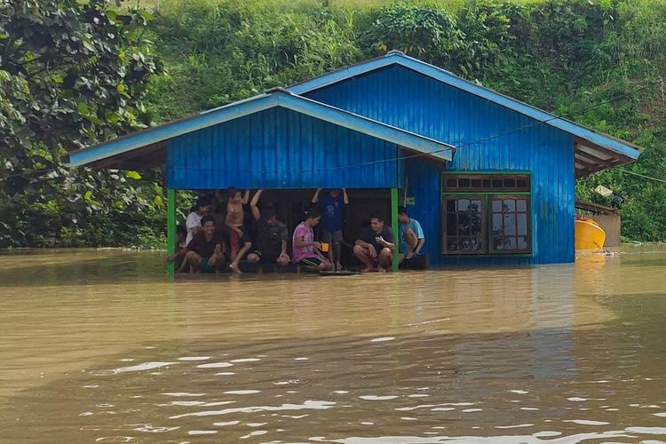 Terbiasa banjir. Sejumlah warga di wilayah perbatasan RI Malaysia berkumpul di tengah musibah banjir yang melanda. Banjir rutin tahunan dianggal hal biasa, sehingga mereka tak pernah panik dan tak ambil pusing dengan musibah yang merupakan kiriman Malaysia ini