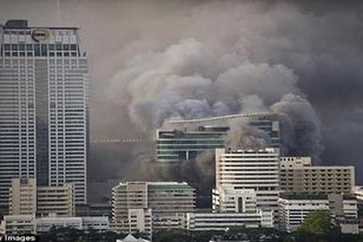 Asap mengepul dari sebuah kawasan komersial yang menjadi kamp massa antipemerintah, Kaus Merah, di Bangkok, Rabu (19/5) 