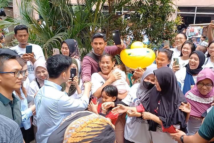 Calon wakil presiden (Cawapres) nomor urut 2, Gibran Rakabuming Raka menyapa dan meyalam tangan warga di Kawasan Rusun Cilincing, Jakarta Utara, Sabtu (9/12/2023).
