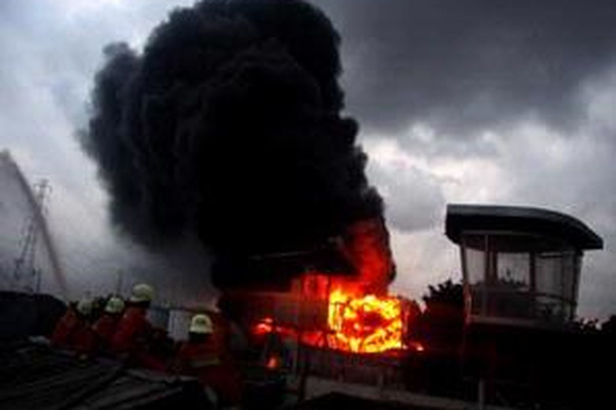 Petugas pemadam kebakaran menyemprotkan air pada rumah penduduk agar kobaran api tidak merembet saat terjadi kebakaran tangki nomor 24 Depo Pertamina Plumpang, Jakarta Utara, Senin (19/1). Petugas akhirnya berhasil memadamkan api sekitar pukul 06.35WIB. 