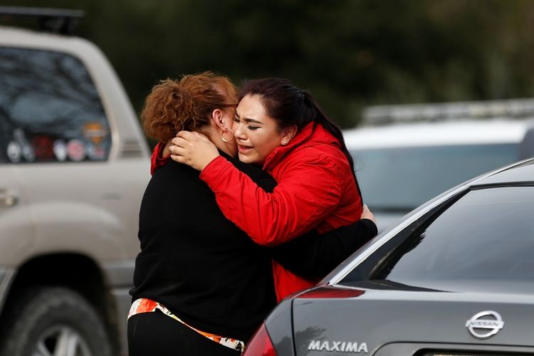 Karyawan Rumah Veteran Vanessa Flores (kanan) sambil menangis mencoba menguatan hati koleganya dalam drama penyekapan yang terjadi di Yountville, California, Jumat (9/3/2018). Penyekapan fasilitas perawatan bagi veteran perang tersebut berakhir dengan kematian tiga orang sandera beserta sang pelaku.