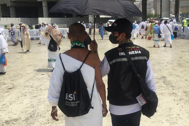 Petugas Haji tengah membantu jamaah.