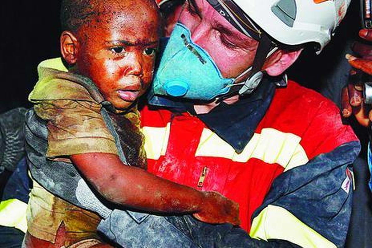 Seorang anggota tim penyelamat Spanyol, Kamis (14/1), membawa anak berusia dua tahun, Redjeson Hausteen Claude, yang dapat diselamatkan dari reruntuhan sebuah rumah akibat gempa dahsyat, Selasa lalu, di Port-au-Prince.