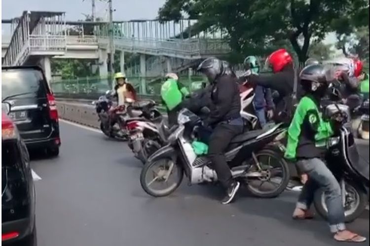 Pemotor gotong royong angkat motor dari jalur TransJakarta
