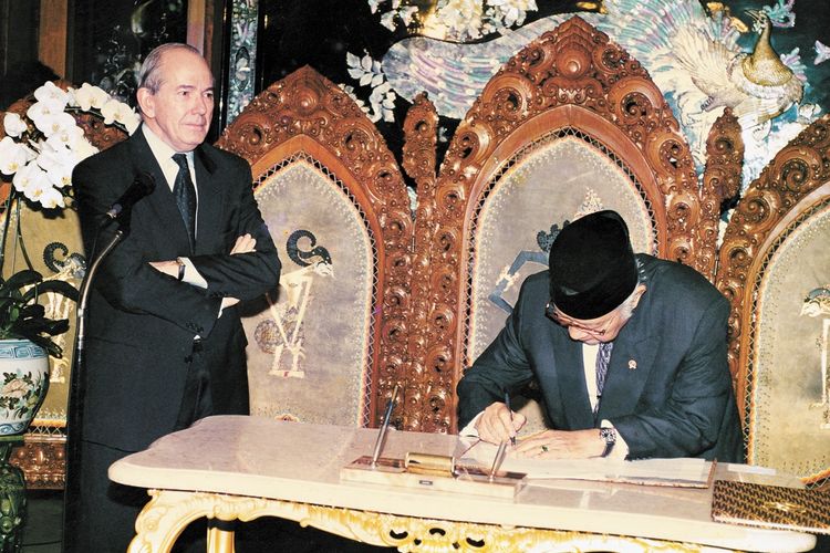 Direktur Pelaksana Dana Moneter Internasional (IMF) Michel Camdessusmenyaksikan Preisden Soeharto menandatangani nota kesepakatan bantuan di Jalan Cendana, Jakarta, pada 15 Januari 1998.