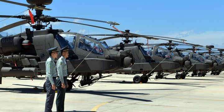 Dua tentara Taiwan berdiri di depan helikopter serbu Apache AH-64E buatan AS saat upacara komisioning di pangkalan militer di Taoyuan, Selasa (17/7/2018).