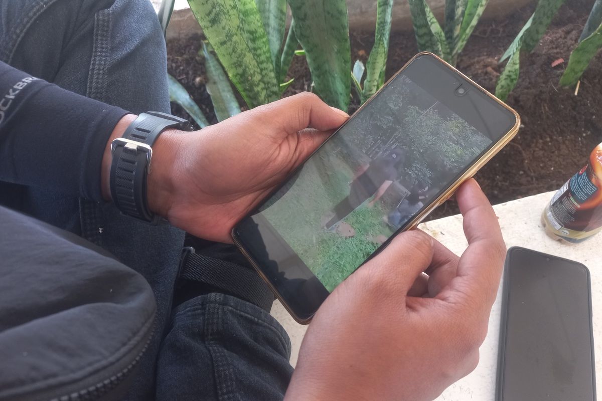 Warga Sumedang menonton video viral sejumlah wanita saling jambak di sebuah kebun di Situraja, Sumedang, Jabar, Kamis (11/7/2024). KOMPAS.com/AAM AMINULLAH