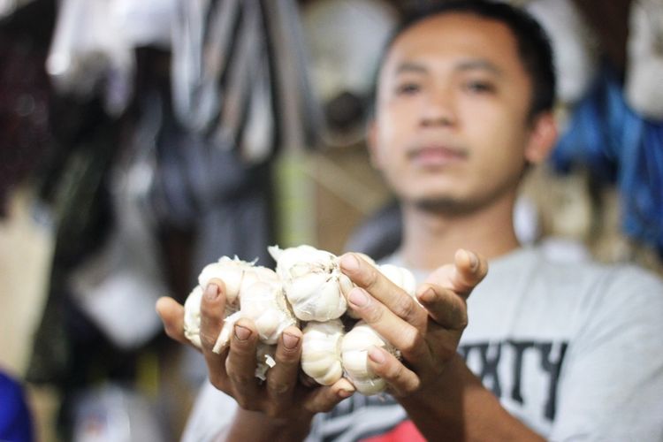 Seorang pedagang di Pasar Muka Cianjur, Jawa Barat memerlihatkan bawang putih dagangannya yang mengalami kenaikan harga dalam beberapa pekan terakhir.