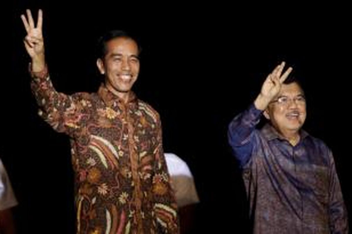 Presiden dan Wakil Presiden terpilih, Joko Widodo (Jokowi) dan Jusuf Kalla (JK) melambaikan salam tiga jari usai memberikan pidato kemenangan, di sebuah kapal pinisi di Pelabuhan Sunda Kelapa, Jakarta Utara, Selasa (22/7/2014). Berdasarkan rekapitulasi suara yang dihitung oleh Komisi Pemilihan Umum (KPU), Jokowi-JK unggul di Pilpres 2014 atas pasangan Prabowo Subianto-Hatta Rajasa. KOMPAS IMAGES/RODERICK ADRIAN MOZES