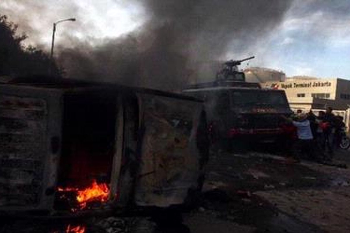 Massa berusaha menggulingkan kendaraan water canon milik polisi saat bentrokan dengan Satpol PP dalam upaya pembongkaran kompleks makam Mbah Priuk di Koja, Jakarta Utara, Rabu (14/4/2010). Bentrokan mengakibatkan sedikitnya seratus orang terluka dan belasan kendaraan roda dua dan empat dibakar massa. KOMPAS IMAGES/DHONI SETIAWAN
