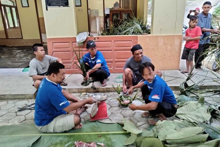 Warga membagikan daging dengan dhekon atau wadah dari anyaman daun kelapa di Pedukuhan Kroco, Kalurahan Sendangsari, Kapanewon Pengasih, Kabupaten Kulon Progo, Daerah Istimewa Yogyakarta, pada Sabtu (9/7/2022).