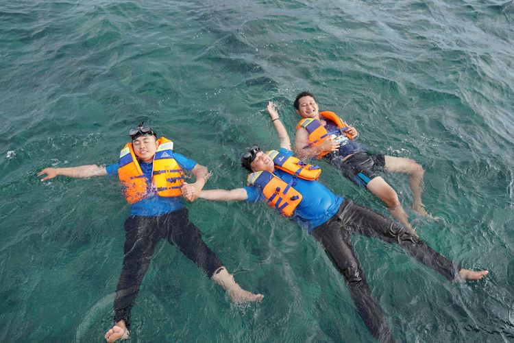 Pengunjung menikmati relaksasi dengan mengapung di pantai Pulau Lengkuas, Belitung, Rabu (12/7/2023).