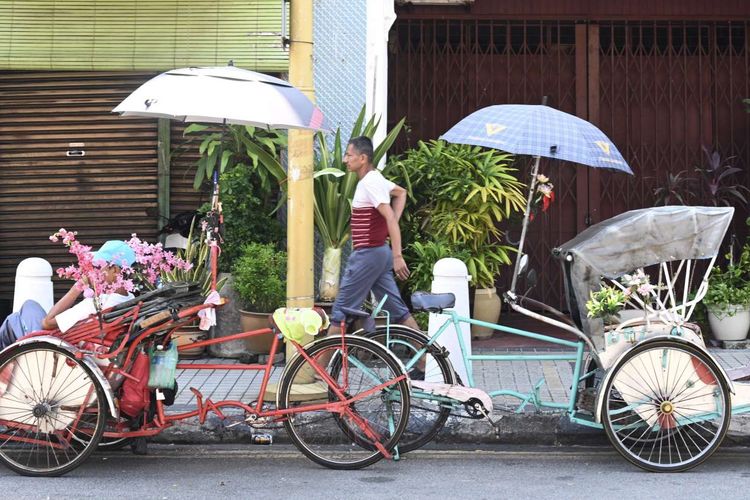 Tukang becak di Penang menunggu penumpang pada hari pertama lockdown di Malaysia, Rabu (18/3/2020). Pemerintah Malaysia mengumumkan keputusan melakukan lockdown selama dua pekan untuk memerangi virus corona.