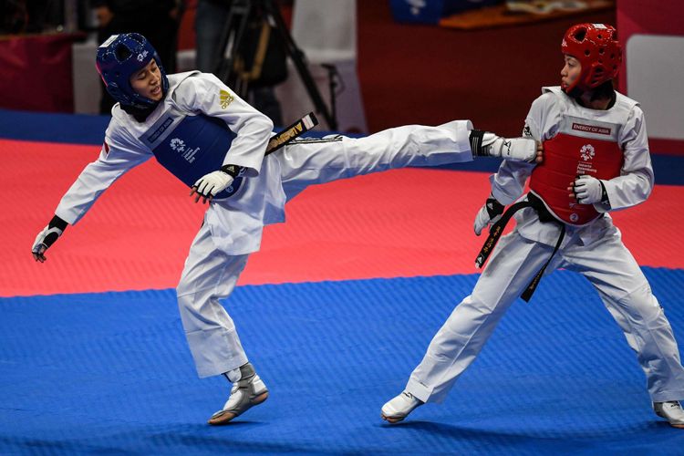 Taekwondoin putri Indonesia Titania Fajrin (biru) saat melawan taekwondoin putri Taiwan Hung Y pada partai 32 besar 49 kg, pada Asian Games 2018 di Jakarta Convention Center, Kamis (23/8/2018). Langkah Titania Fajrin terhenti di partai ini dan kalah dengan skor 4-13.
