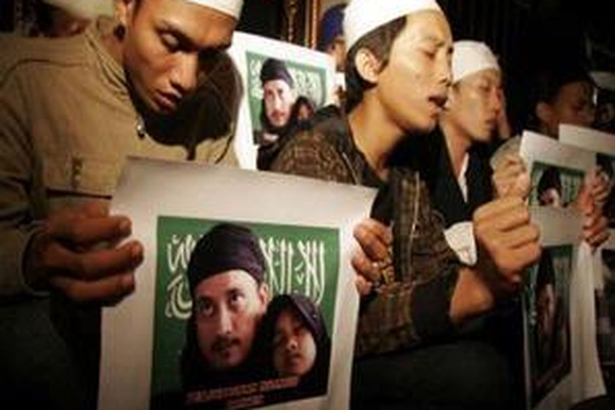 warga berdoa sambil membawa poster terpidana mati Bom Bali I, Abdul Aziz alias Imam Samudra di Lopang Gede, Serang, Banten, Minggu (9/11) dinihari.