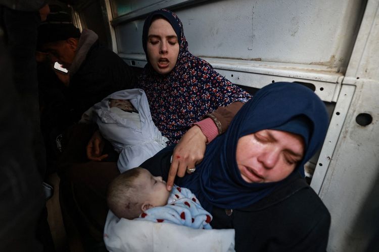 Ibu dari bayi kembar Naeem dan Wissam, tewas dalam serangan udara Israel semalam, berduka atas kematian mereka saat mereka diangkut dengan kendaraan menjelang pemakaman mereka di Rafah di Jalur Gaza selatan pada tanggal 3 Maret 2024.