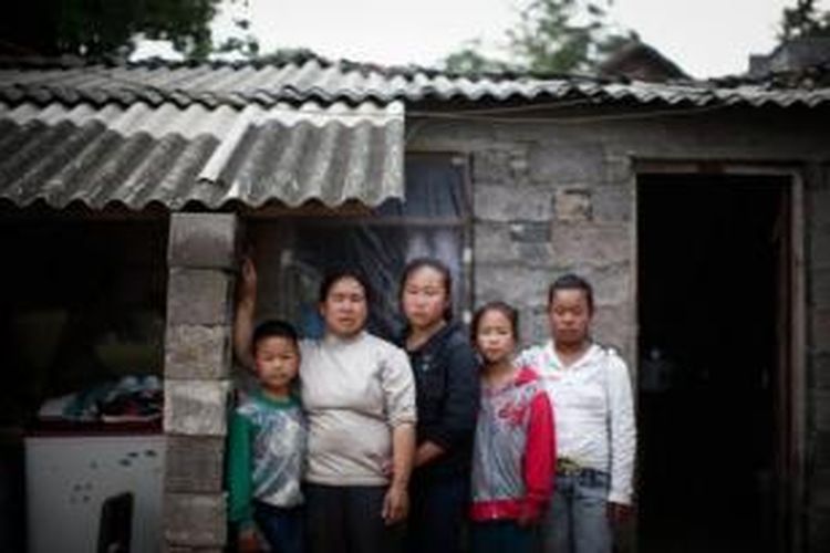 Wu Jingmin (36), istri mendiang Wang Guangrong, bersama tiga putri dan seorang putranya. Wu Jingmin berkata suaminya akan bahagia karena saat ini anak-anaknya bisa mendapatkan pendidikan yang layak.