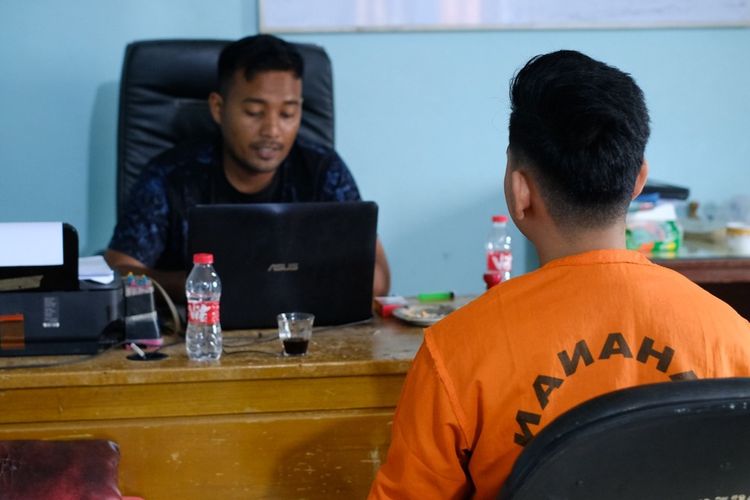 SA (21) warga Aceh Utara saat menjalani pemeriksaan polisi, Selasa (9/1/2024). Dia ditangkap karena diduga menyebarkan foto bugil mantan istrinya.