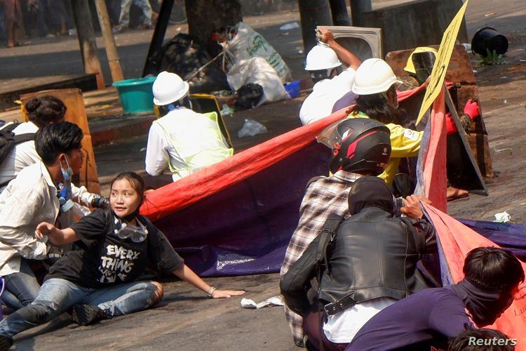 Protesters lie on the ground after police opened fire to disperse an anti-coup protest in Mandalay, Myanmar, (3/3/2021). Among them Angel, 19, bottom left, also known as Kyai Sin, took cover before she was shot in the head