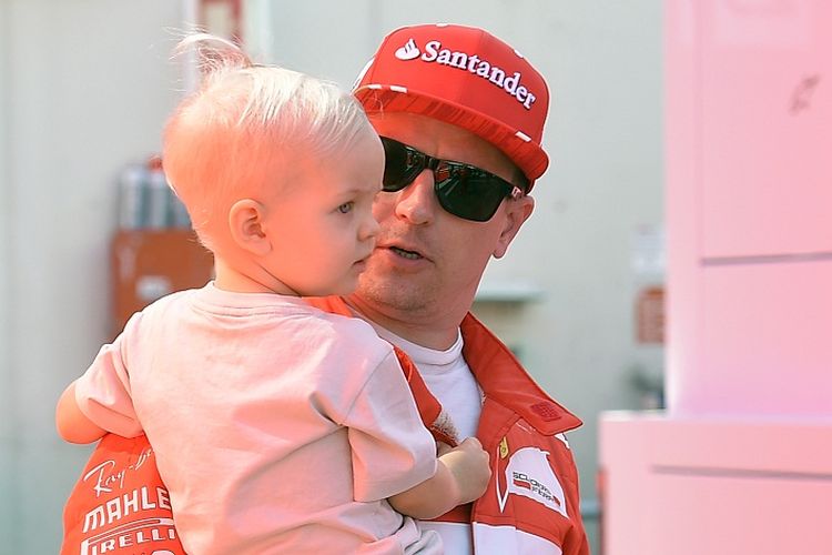 Pebalap Ferrari, Kimi Raikkonen, sedang menggendong anaknya, Robin, di Circuit de Barcelona-Catalunya, 10 Maret 2017.