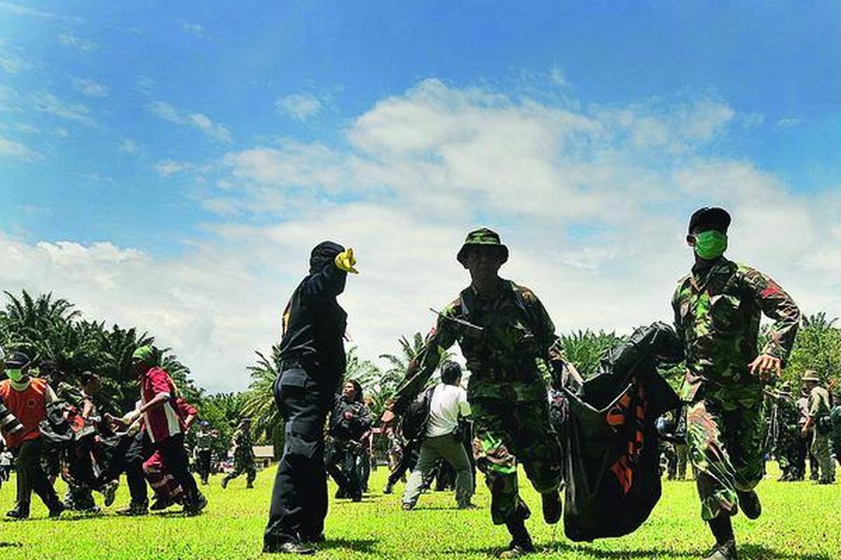 Tim evakuasi mengangkat jenazah korban pesawat CASA 212-200 di Lapangan Turangie, Kecamatan Bahorok, Kabupaten Langkat, Sumatera Utara, setelah diangkut dengan helikopter dari Bukit Hulusekelem, Kabupaten Langkat, Minggu (2/10). Jenazah para korban kemudian dibawa ke Rumah Sakit Umum Adam Malik di Medan dengan menggunakan ambulans.