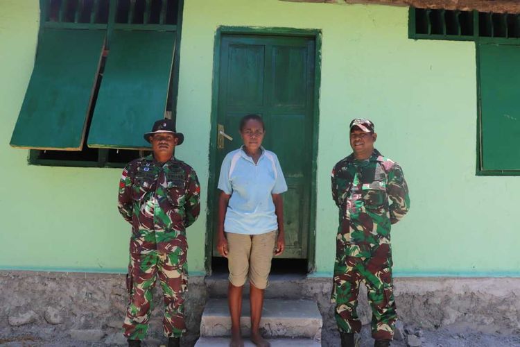 PHOTO:Agustina Hoar, berpose bersama anggota TNI di depan rumahnya yang telah direhap