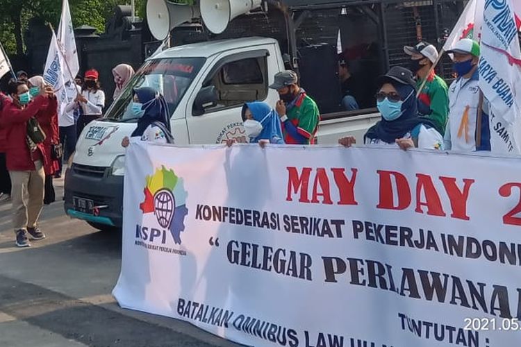 Workers stage a protest to mark international labor day in front of the office of the Central Java governor on Saturday, May 1, 2021.  