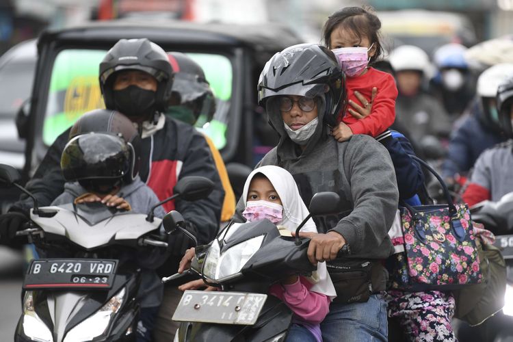 Sejumlah pemudik bersepeda motor melintas di kawasan Pasar Bulakamba, Brebes, Jawa Tengah, Sabtu (30/4/2022). Pada H-2 Lebaran lalu lintas di kawasan itu agak terhambat karena adanya pasar tumpah yang dipenuhi warga sekitar berbelanja berbagai bahan pokok.