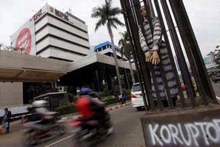 Aktivis anti korupsi memasukan boneka koruptor ke dalam tiang pancang dan diborgol di depan Gedung Komisi Pemberantasan Korupsi, Jakarta, Rabu (12/12/2012). Pemasangan boneka koruptor tersebut ditujukan sebagai peringatan kepada para koruptor, dalam rangka Hari Anti Korupsi.  