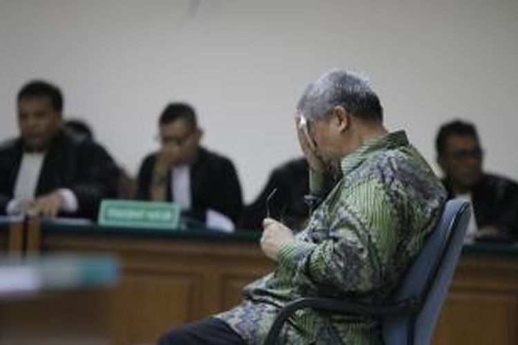 Terdakwa, mantan Ketua Mahkamah Konstitusi, Akil Mochtar menjalani sidang perdana di Pengadilan Khusus Tindak Pidana Korupsi, Jakarta, Kamis (20/2/2014). Sidang perdana dengan agenda pembacaan dakwaan tersebut terkait kasus dugaan suap penanganan sengketa Pilkada di Mahkamah Konstitusi. KOMPAS IMAGES/KRISTIANTO PURNOMO