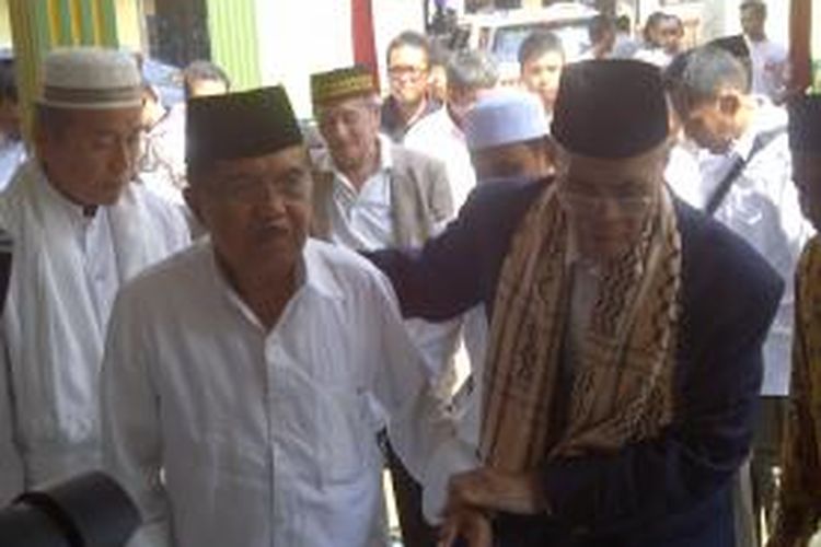 Cawapres nomor urut dua Jusuf Kalla menggandeng pimpinan Pondok Pesantren Suryalaya, Kabupaten Tasikmalaya, KH Mohammad Zein, saat tiba di pesantren tersebut, Rabu (25/6/2014) siang. 