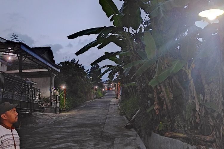 Ketua Desa Mandiri Energi (DME) Desa Gedangan Supomo mengecek pijar lampu di depan rumahnya di Desa Gedangan, Kecamatan Cepogo, Kabupaten Boyolali, Jawa Tengah, Selasa (19/10/2021). Sekitar 30 lampu di desa tersebut dialiri listrik yang bersumber dari pembangkit listrik tenaga biogas (PLTBg).