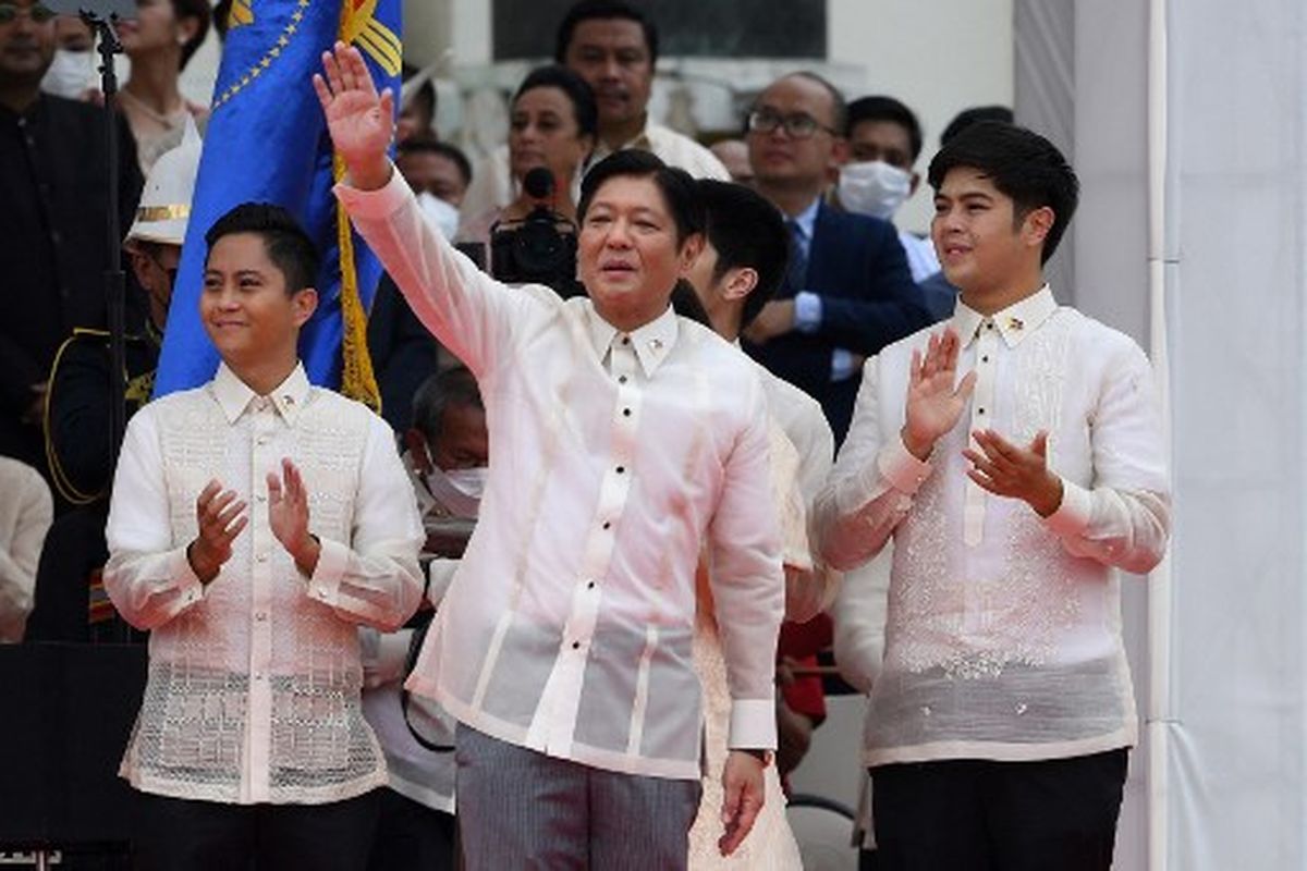 Presiden baru Filipina Ferdinand Marcos Jr (tengah) melambaikan tangan kepada para pendukungnya bersama putra-putranya, setelah dilantik sebagai pemimpin baru negara itu, dalam upacara peresmian di Museum Nasional di Manila pada 30 Juni 2022.