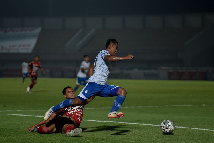 Winger Persib Bandung, Febri Hariyadi (putih), melewati hadangan bek Bali United Haudi Abdillah (merah) saat kedua tim bentrok di pekan ketiga Liga 1 2021-2022 di Stadion Indomilk Arena, Tangerang, Sabtu (18/9/2021). 