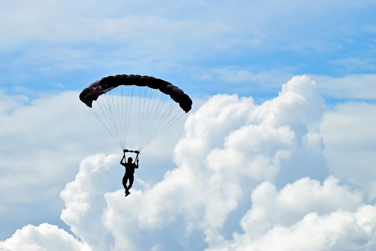 Parachuter silhouette on blue sky