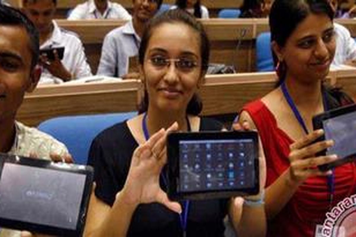 Tiga orang pelajar memperlihatkan Aakash (langit), yang disebut-sebut sebagai komputer tablet termurah di dunia. (REUTERS/Parivartan Sharma)
