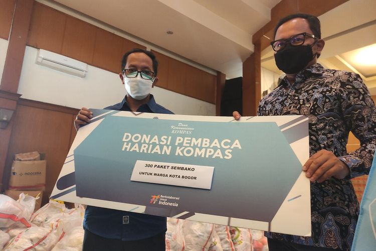 Wali Kota Bogor Bima Arya Sugiarto (kanan) dan Ketua Yayasan Dana Kemanusiaan Kompas Tomy Trinugroho (kiri) saat penyerahan bantuan berupa 300 paket sembako untuk warga terdampak Covid-19, di Gudang Logistik, Kota Bogor, Jawa Barat, Jumat (6/8/2021).