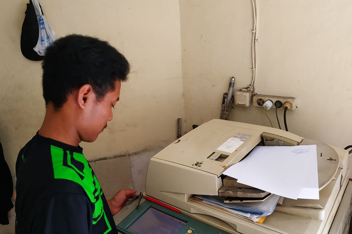 Rahmat (20), juru fotokopi di Mapolres Metro Bekasi Kota tengah melayani permintaan fotokopi dokumen untuk keperluan para CPNS, Rabu (13/11/2019).