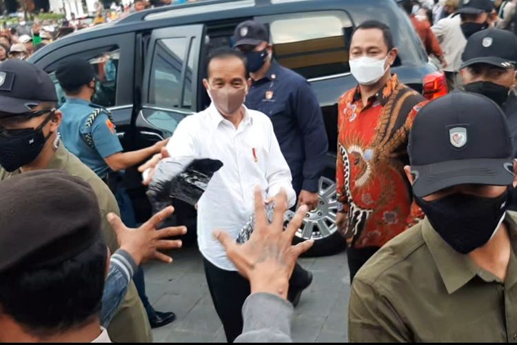Jokowi saat membagikan kaos oblong kepada warga di Semarang, Rabu (5/1/2022)