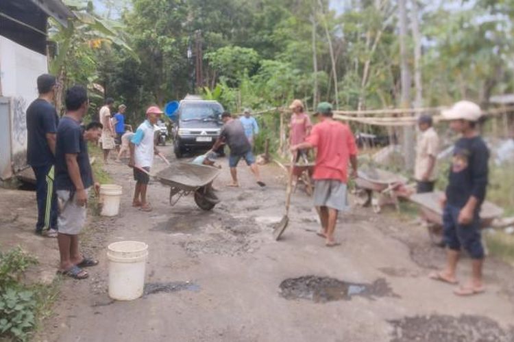 Masyarakat dari Desa Sidanegara dan Selanegara, Kabupaten Purbalingga saat gotong royong untuk memperbaiki jalan yang berlubang, Minggu (12/10/2025).  