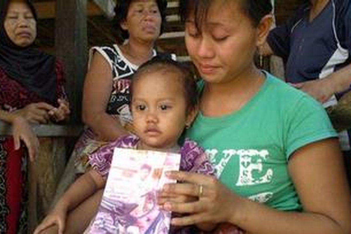 Keluarga almarhum Syamsul Rijal (25), TKI asal Kabupaten Bulukumba, Sulawesi Selatan yang tewas dibunuh di Malaysia memperlihatkan foto sembari menunggu jenazah almarhum.