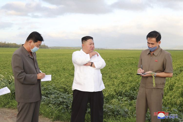 Dalam foto tak bertanggal yang disediakan pada 28 Agustus 2020, nampak Pemimpin Korea Kim Jong Un berrbicara dengan pejabat setempat dalam kunjungannya ke Provinsi Hwanghae Selatan, di mana Topan Bavi mendarat pada 27 Agustus 2020.