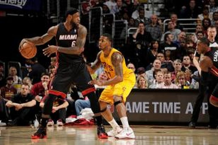 Pebasket Cleveland Cavaliers, LeBron James (hitam) bersiap melewati pemain Cleveland Cavaliers, Alonzo Gee, pada laga lanjutan kompetisi NBA di The Quicken Loans Arena, Rabu (27/11/2013).