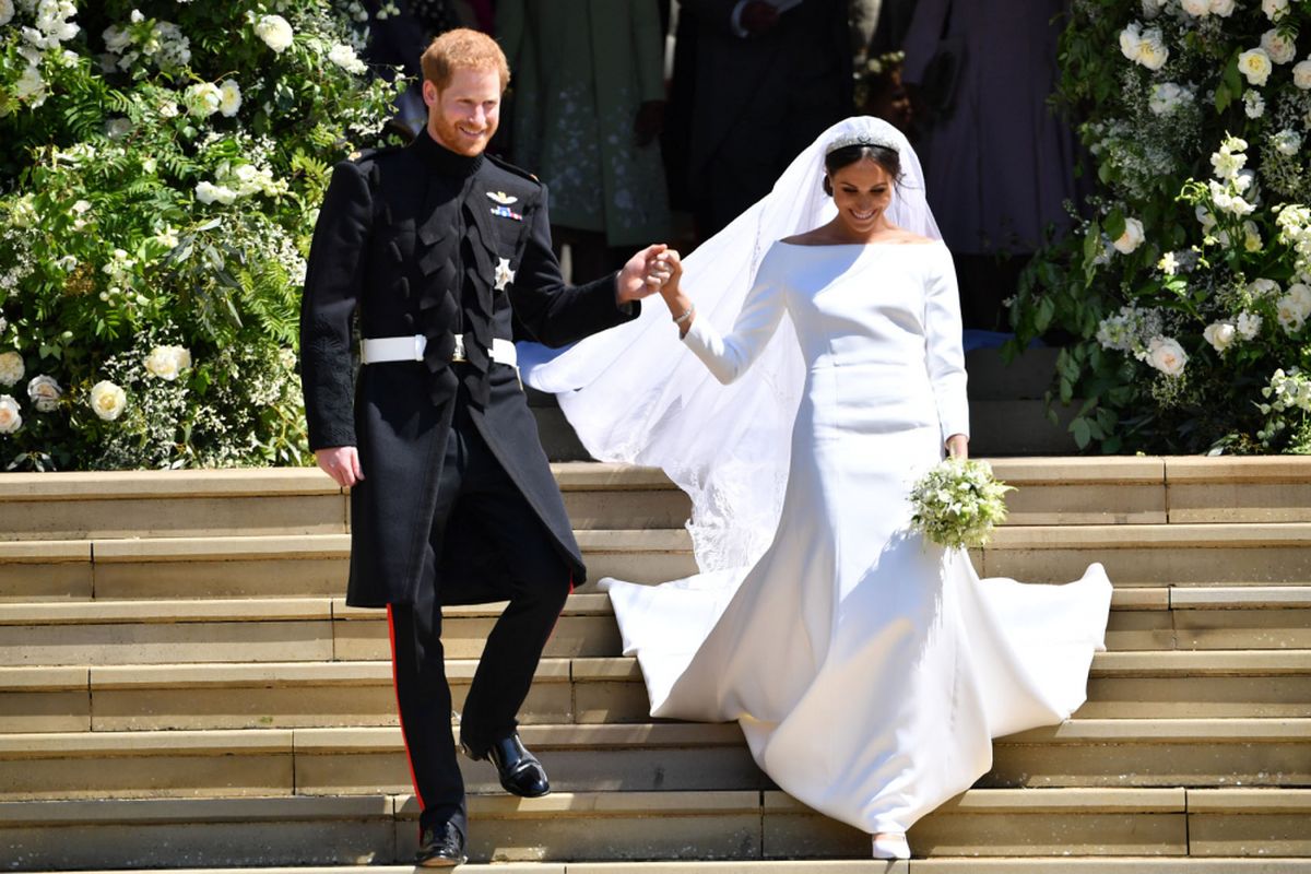 Pangeran Harry, Duke of Sussex dan istirnya Meghan, Duchess of Sussex saat keluar dari St Georges Chapel, Windsor Castle, 19 Mei 2018 setelah upacara pernikahan mereka. / AFP PHOTO / POOL AND AFP PHOTO / Ben STANSALL