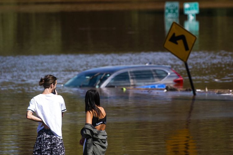 Orang-orang melihat mobil yang terendam banjir akibat sisa-sisa Badai Ida di Somerville, New Jersey, Kamis (2/9/2021).