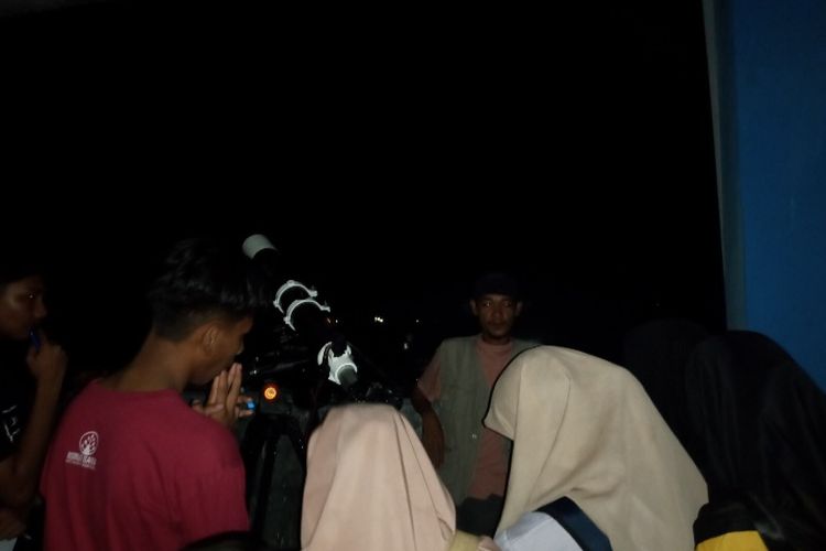 Foto: Mahasiswa dan pelajar di Kota Maumere, Kabupaten Sikka sedang memantau fenomena gerhana bulan di IKIP Muhammadiyah Maumere, Selasa (8/11/2022) malam.
