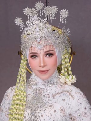 Melly Goeslaw tampil anggun dengan kebaya putih, siger megah, dan ronce melati di perayaan 30 tahun pernikahan, kental nuansa adat Sunda.